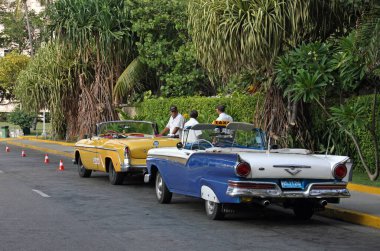 Havana, Küba - 2 Temmuz 2019: Havana, Küba 'da klasik arabalarının yanında duran taksi şoförü.