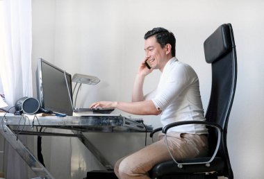 Oturma odasında dizüstü bilgisayarla çalışan bir adam.