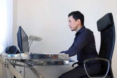 Evden masa başında çalışan bir adam.