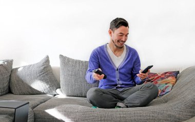 İkinci ekran - Uzaktan kumandalı ve akıllı telefonlu gülümseyen adam