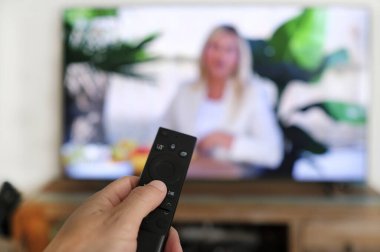 Uzaktan kumanda ve ekran - en sevilen TV programını izliyor