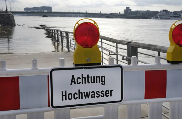 Extreme weather - Warning sign in German at the entrance to a flooded pedestrian zone in Cologne, Germany