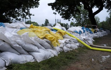 Aşırı hava - Dusseldorf, Almanya 'daki su basmış bodrumlardan su pompalamak için bir sıra kum torbası ve hortum