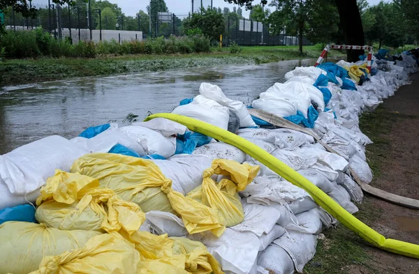 Extreme weather - a line of sand bags and hoses to pump water out of flooded basements in Dusseldorf, Germany