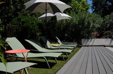 Güneşte güneş gözlükleriyle terasta güneşleniyorlar.