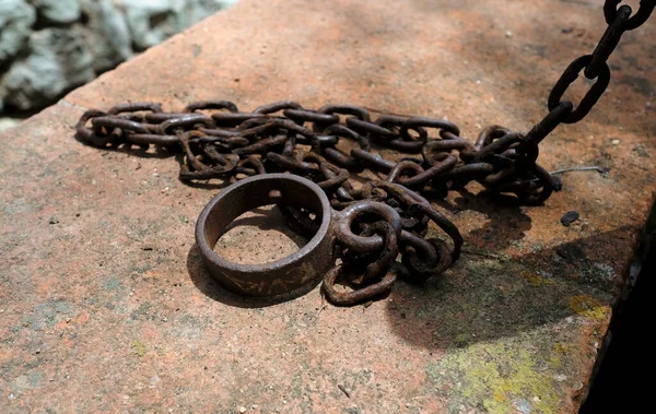 Paslı metal zincir bir limanın duvarına bağlı.