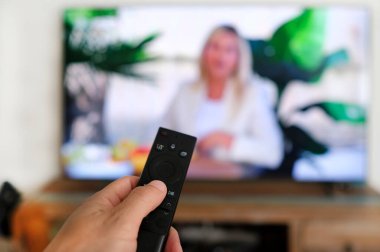 Uzaktan kumanda ve ekran - en sevilen TV programını izliyor