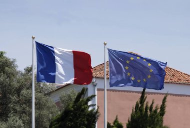 Güneşli bir günde Avrupa Birliği bayrağının yanında Fransız ulusal bayrağı
