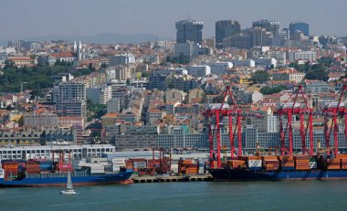 Lizbon, Portekiz - 10 Mayıs 2023: Lizbon, Portekiz limanının ön planda birçok kargo gemisi ve arka planda şehir manzarası