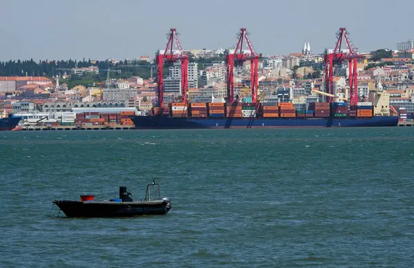 Lizbon, Portekiz - 15 Mayıs 2023: Lizbon, Portekiz limanının arka planında kargo gemileri ve şehir manzarası