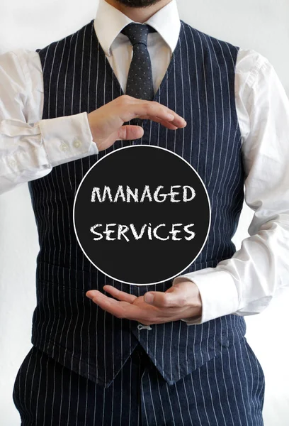 Businessman holding sign with the words Managed Services