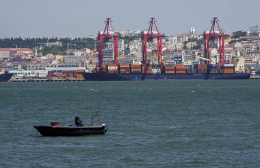 Lizbon, Portekiz - 10 Mayıs 2023: Lizbon, Portekiz limanının ön planda birçok kargo gemisi ve arka planda şehir manzarası