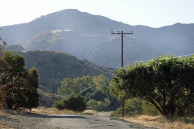 Gün batımında, Towsley Canyon, California 'daki Ed Davis Parkı' ndan geçen boş yol.