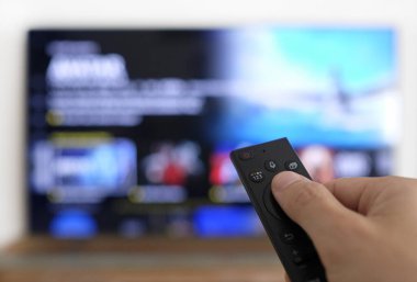Uzaktan kumanda ve ekran - en sevilen TV programını izliyor