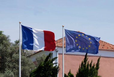 Güneşli bir günde Avrupa Birliği bayrağının yanında Fransız ulusal bayrağı