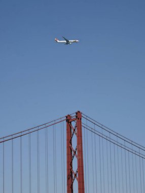 Lizbon, Portekiz - 20 Mayıs 2023: Portekiz bayrak taşıyıcısı TAP Air Portugal, Lizbon 'daki ünlü asma köprüsünün üzerinde dalgalanmaktadır. 