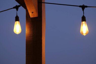 Gece karanlığında karanlık bir gökyüzüne karşı ampul.