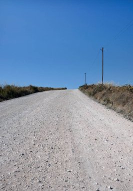 Portekiz 'in kırsal kesimlerinden birinde elektrik hattı ve yanındaki direklerin olduğu boş bir yol.