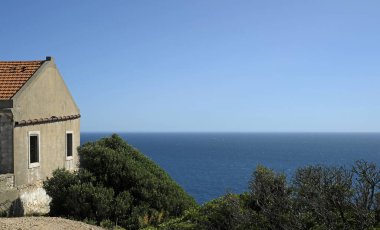 Güneşli bir günde Portekiz kıyısı boyunca terk edilmiş bir ev.