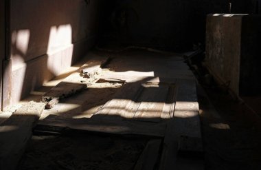Terk edilmiş bir binanın içindeki boş bir odayı aydınlatan güneş ışığı.