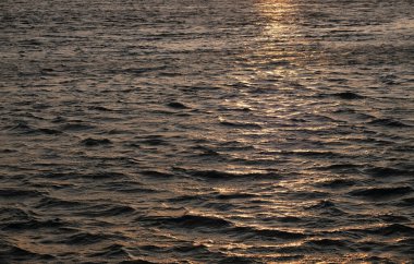 Gün batımında hareket halindeki okyanus dalgalarına yakın çekim