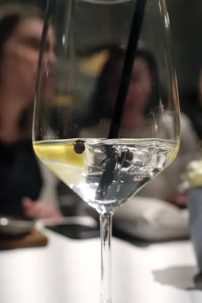 Selective focus on a glass of Gin & Tonic during a dinner event