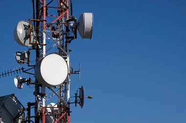 Mavi gökyüzüne karşı çoklu uydu anteni olan telekomünikasyon anteni