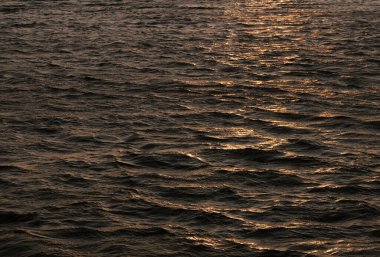 Gün batımında hareket halindeki okyanus dalgalarına yakın çekim