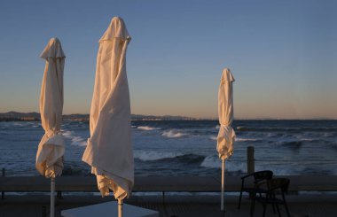 Valencia 'da bir sahil barında kışın kapalı şemsiyeler.