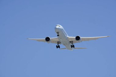 Mavi gökyüzüne yaklaşan uçak