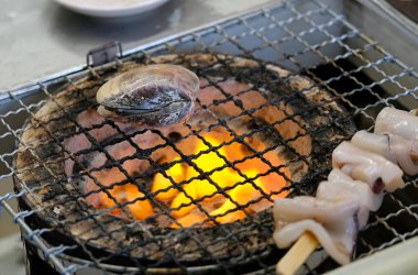 Enoshima, Japonya 'da bir ızgarada midye ve diğer deniz ürünlerine yakın çekim