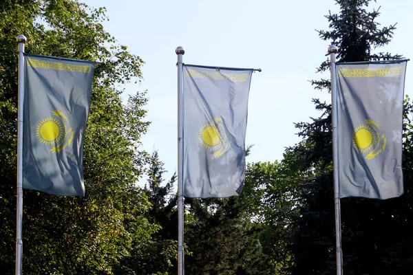 stock image Three national flags of Kazakhstan on flag poles in the city of Almaty on a sunny day