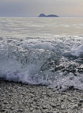 Girit, Matala 'daki çakıl taşı plajına dalgalar geliyor.