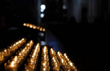 Karanlık bir kilise odasını aydınlatan bir sürü küçük mum.