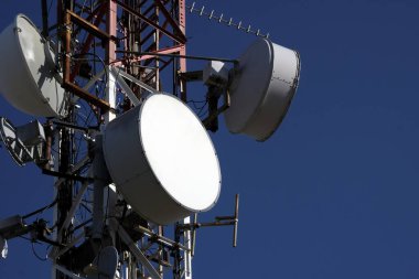 Mavi gökyüzüne karşı çoklu uydu anteni olan telekomünikasyon anteni