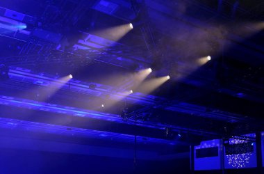 Çevre ve spot ışıkları tavandan parlayan karanlık bir odada