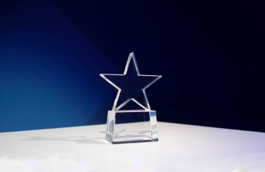 Spot ışıkları ve kopyalama alanı olan bir masada yıldız şeklinde ödül