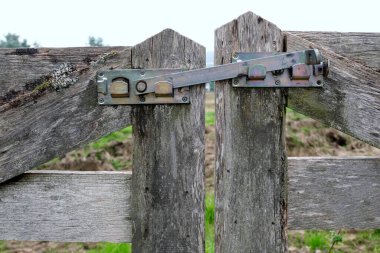 Metal menteşeli bir arazide kapalı bir kapı.