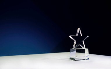 Spot ışıkları ve kopyalama alanı olan bir masada yıldız şeklinde ödül