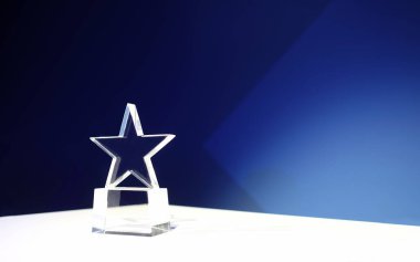 Spot ışıkları ve kopyalama alanı olan bir masada yıldız şeklinde ödül