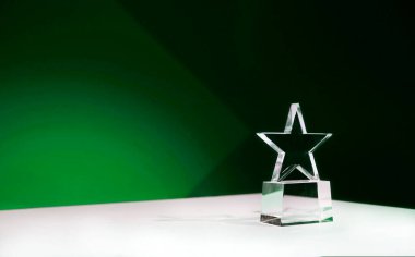 Sürdürülebilirlik ödülü - yıldız şeklinde kristal ödül yeşil spot ışıkları ve kopyalama alanı olan bir masada