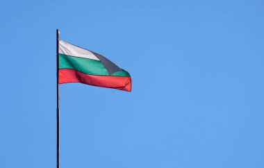 Bulgaristan 'ın ulusal bayrağı mavi gökyüzüne karşı rüzgarda dalgalandı