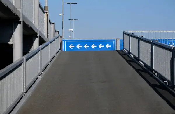 Oklar bir otoparkın sol üst güvertesini gösteriyor.