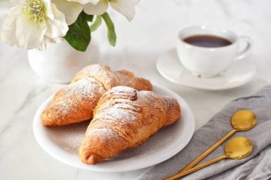 Masada ayçöreği olan kahve. Kahve molası. Kruvasan günü.