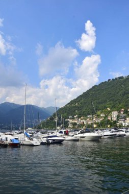 Como Gölü. İtalya. İskeleye demirlemiş yatlar ve tekneler suda sallanıyor..