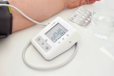 Tonometre yüksek tansiyonu gösteriyor, bir hap alman gerekiyor..