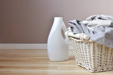 Bir şişe deterjan ve kirli çamaşırlarla dolu bir sepet..