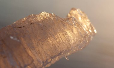 Sabah ışığında donmuş gölün üzerindeki buz kristalleri.