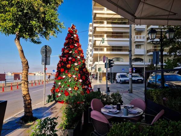 Ana yoldaki erken tatil süslemelerinin gündüz manzarası. Nikis caddesinde, Yunanistan 'ın Selanik kentindeki açık bir oturma alanının yanındaki Noel ağacının şenlikli bölümleri.