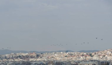 Selanik, Yunanistan - 28 Ekim 2022: Yunan Hava Kuvvetleri helikopterleri bir kentin üzerinde düzende uçuyor. 28 Ekim 'deki Ulusal Oxi Günü geçit töreni sırasında hava gösterisi.